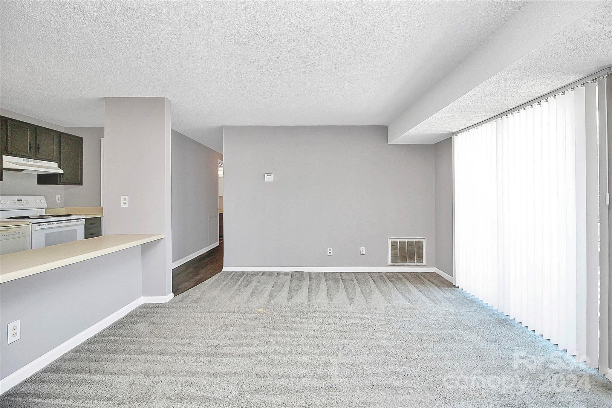 9409 Old Concord Road, Unit M Charlotte, NC 28213 - Photo 11 of 29 a view of an empty room with window and wooden floor