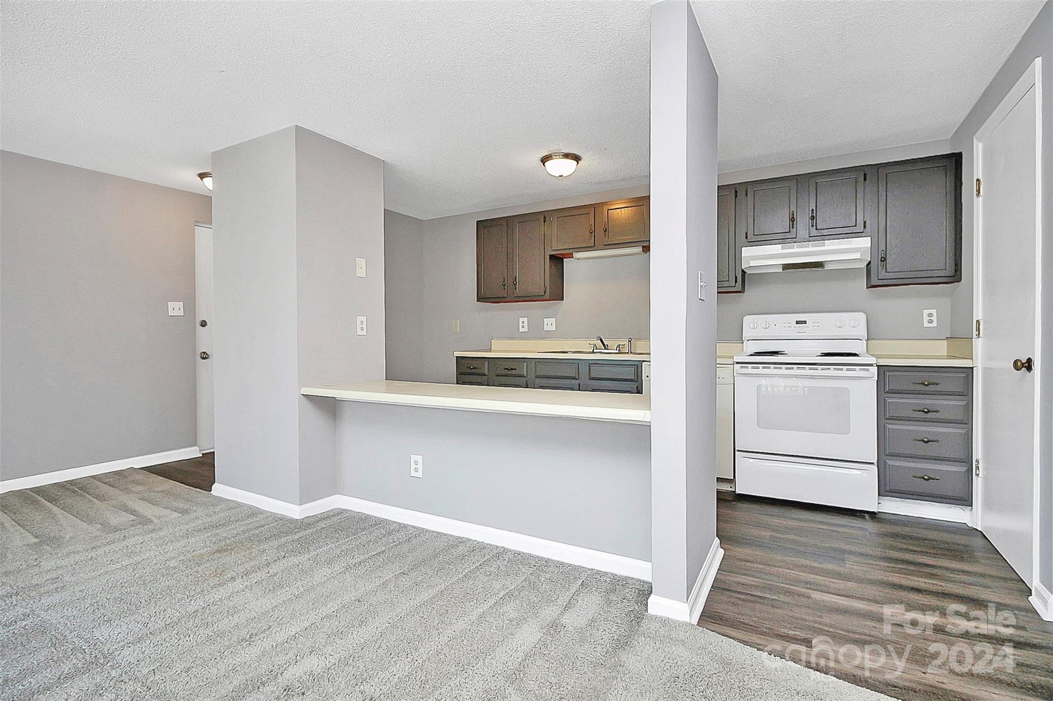 9409 Old Concord Road, Unit M Charlotte, NC 28213 - Photo 15 of 29 a kitchen with a refrigerator stove and white cabinets