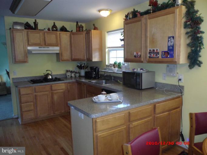 7013 Friendship Road Clinton, MD 20735 - Photo 8 of 15 a kitchen with a sink cabinets and wooden floor