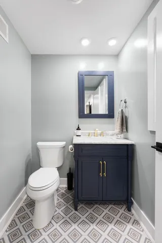a bathroom with a granite countertop toilet sink and mirror