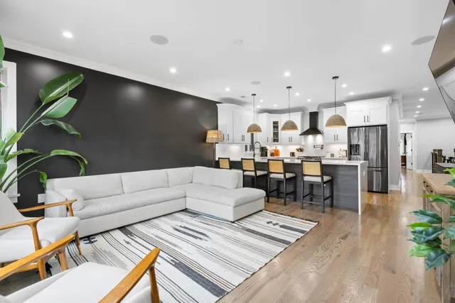 a living room with stainless steel appliances kitchen island granite countertop furniture and a rug