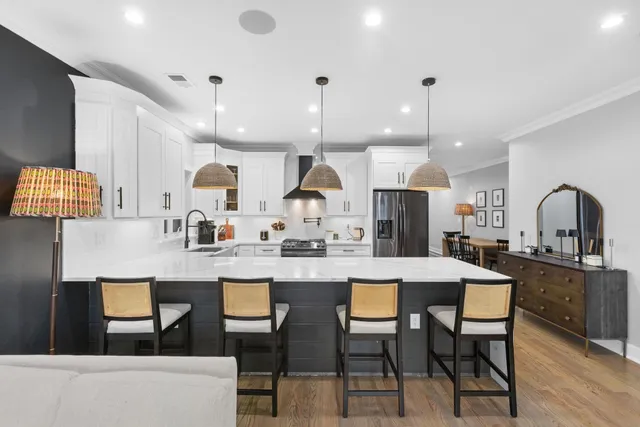 a kitchen with stainless steel appliances kitchen island granite countertop a table chairs and a sink