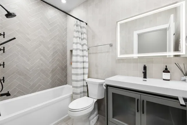 a bathroom with a sink toilet vanity and tub