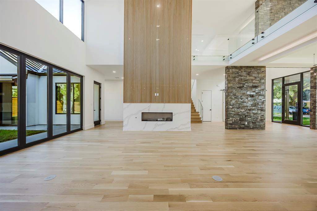 5723 Meletio Lane Dallas, TX 75230 - Photo 12 of 38 Unfurnished living room with a premium fireplace, a towering ceiling, light wood-type flooring, and recessed lighting