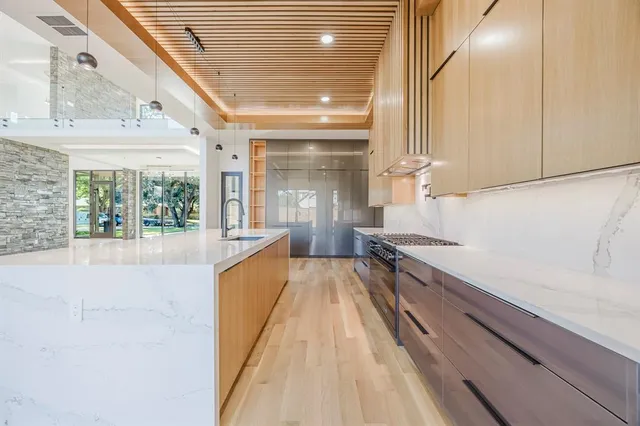 a view of a kitchen with a refrigerator and wooden floor
