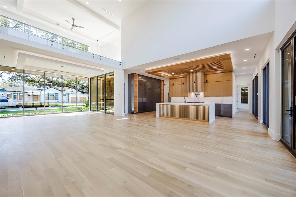 5723 Meletio Lane Dallas, TX 75230 - Photo 19 of 38 Unfurnished living room featuring light wood finished floors, recessed lighting, a towering ceiling, and a ceiling fan
