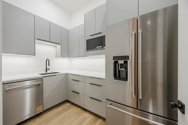 a bathroom with a granite countertop sink and a toilet