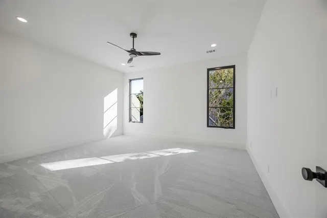 an empty room with floor to ceiling window and yard