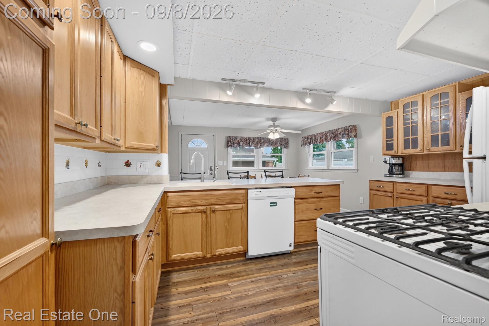 7961 Merrick Street Taylor, MI 48180 - Photo 7 of 39 Wood-finish flooring, light wood cabinetry, white countertops, built-in dishwasher, and a white gas range
