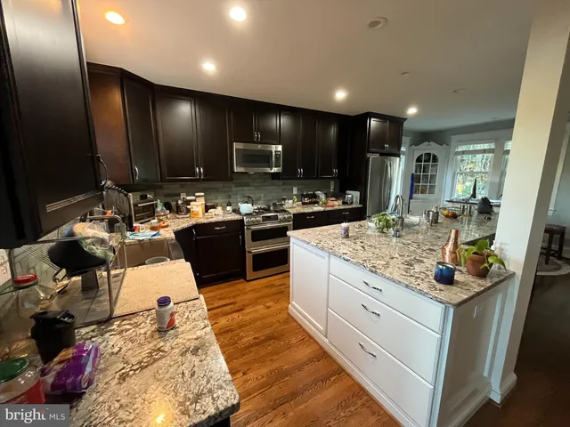 a kitchen with stainless steel appliances kitchen island granite countertop a sink and cabinets