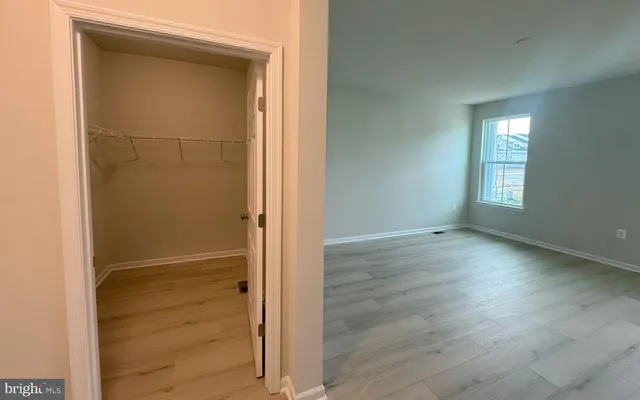 an empty room with windows and closet