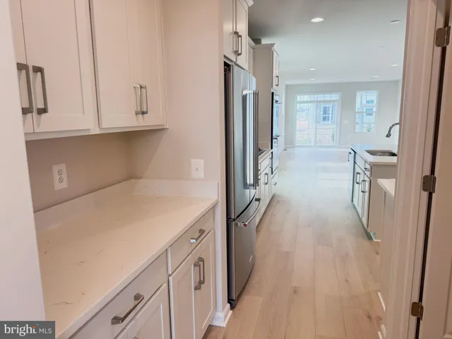 a kitchen with white cabinets and refrigerator