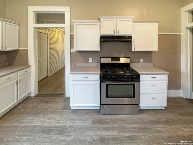 a kitchen with granite countertop a stove and a cabinets