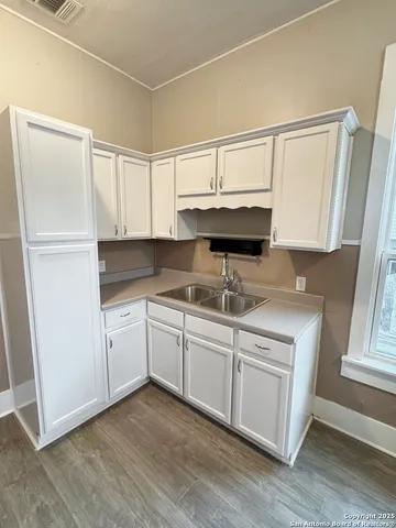 a kitchen with stainless steel appliances granite countertop a sink a stove cabinets and wooden floor