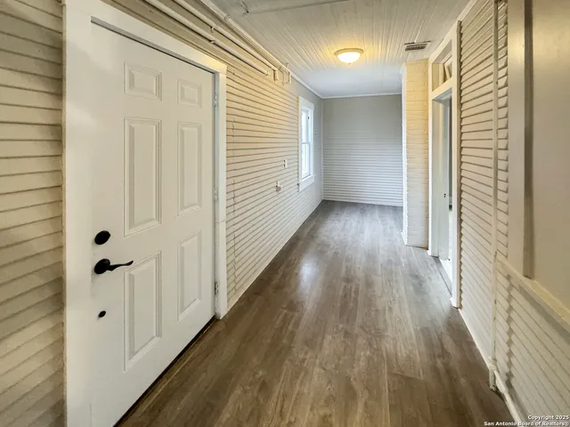a view of a hallway with wooden floor