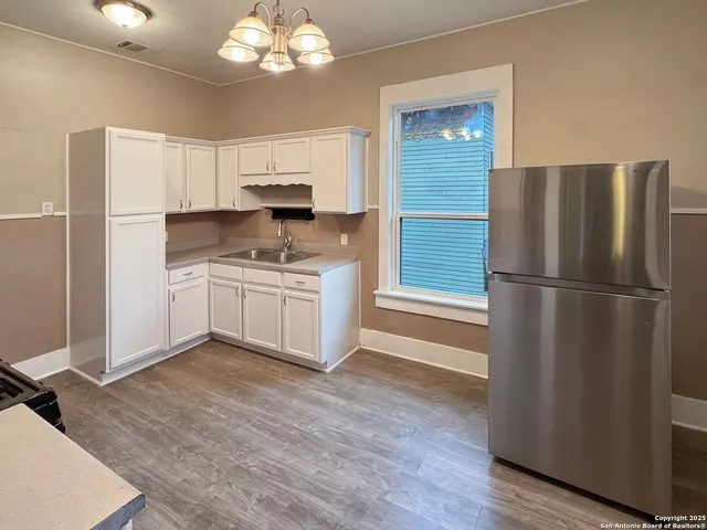 a kitchen with a refrigerator sink and cabinets