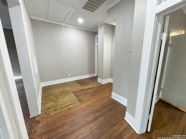 a view of empty room with wooden floor