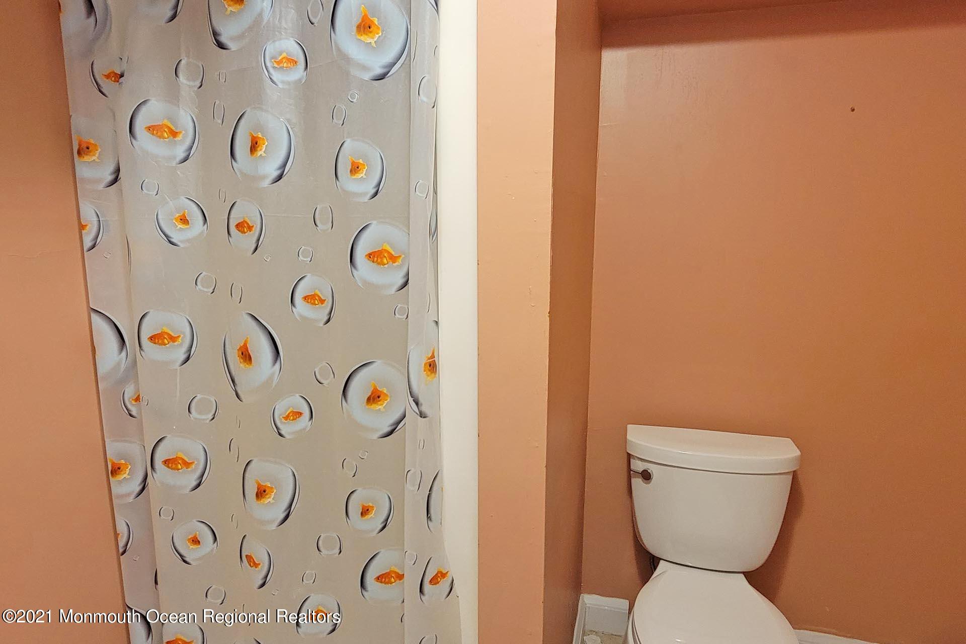 1 Brooklyn Avenue Lavallette, NJ 08735 - Photo 44 of 55 a bathroom with a toilet and a shower curtain