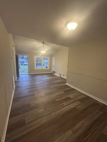 a view of an empty room with wooden floor
