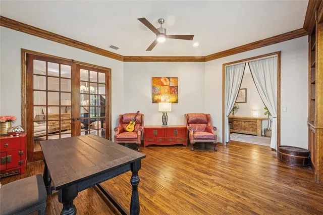 a living room with furniture a large window and wooden floor