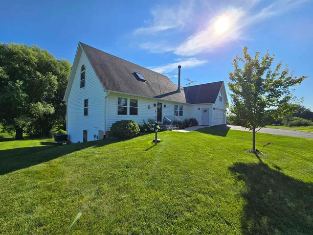a view of a house with a backyard and a tree