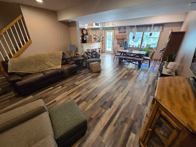 a living room with furniture floor to ceiling window and wooden floor