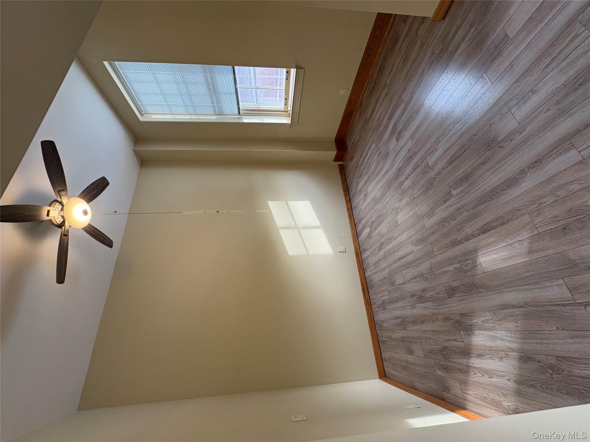 1701 Crompond Road Peekskill, NY 10566 - Photo 10 of 15 an empty room with wooden floor chandelier fan and windows