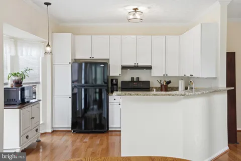 a kitchen with stainless steel appliances a refrigerator sink and white cabinets