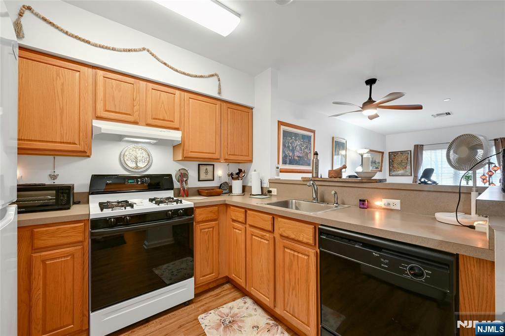 189 Forest Avenue, Unit 117 Paramus, NJ 07652 - Photo 3 of 15 a kitchen with a sink stove and cabinets