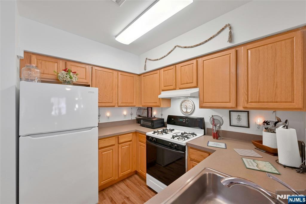 189 Forest Avenue, Unit 117 Paramus, NJ 07652 - Photo 4 of 15 a kitchen with stainless steel appliances granite countertop a refrigerator stove sink and cabinets