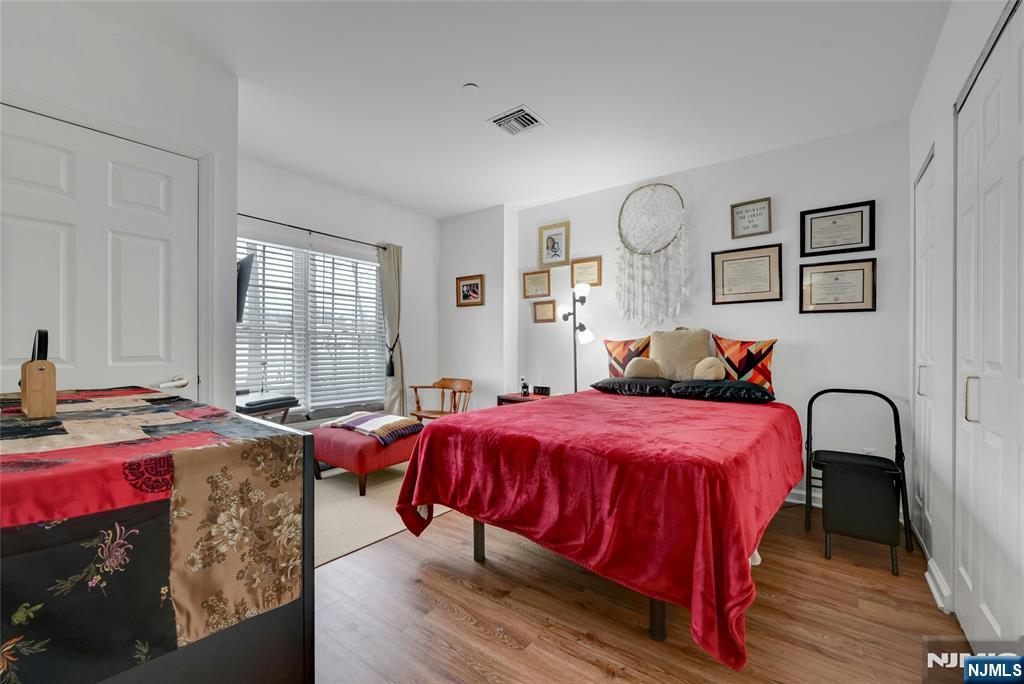 189 Forest Avenue, Unit 117 Paramus, NJ 07652 - Photo 9 of 15 a bedroom with bed and windows