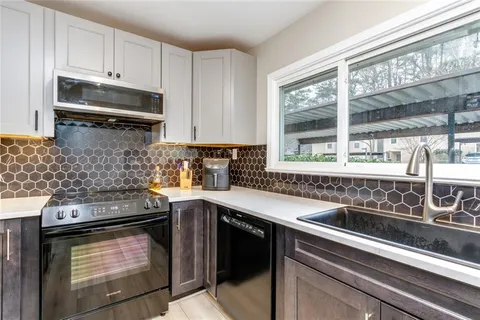 a kitchen with stainless steel appliances granite countertop a sink stove and microwave