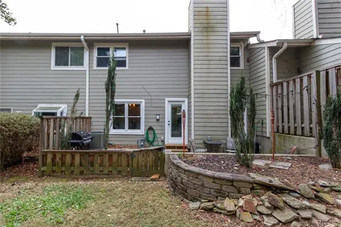 a view of a house with backyard and wooden fence
