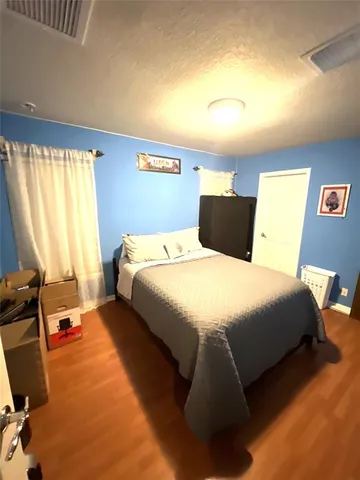 a bedroom with a bed a lamp and a large window