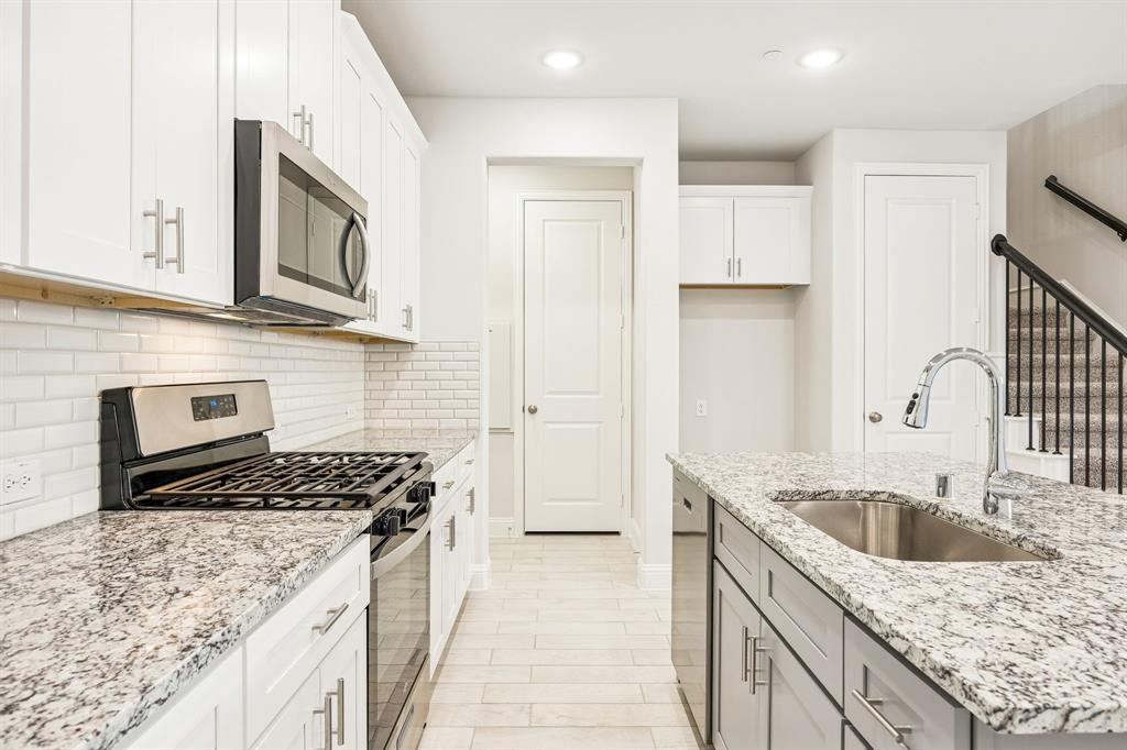 817 Heart Reef Road Plano, TX 75075 - Photo 3 of 21 a kitchen with granite countertop a sink stove and cabinets