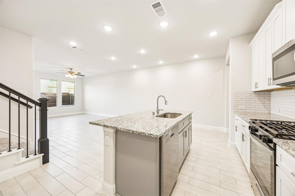 817 Heart Reef Road Plano, TX 75075 - Photo 9 of 21 a kitchen with stainless steel appliances granite countertop a sink and a stove