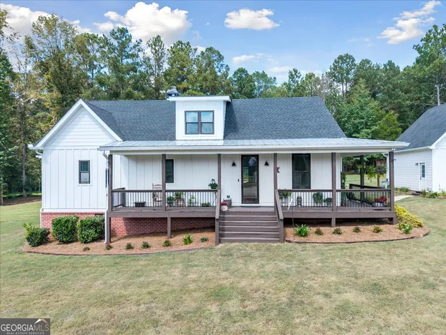 a view of a house with a swimming pool and sitting area