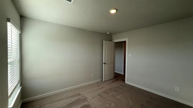 an empty room with closet and windows