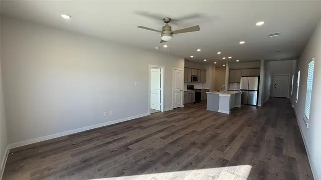 a view of kitchen with refrigerator stove and wooden floor