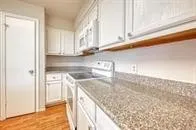a kitchen with granite countertop a sink and a stove