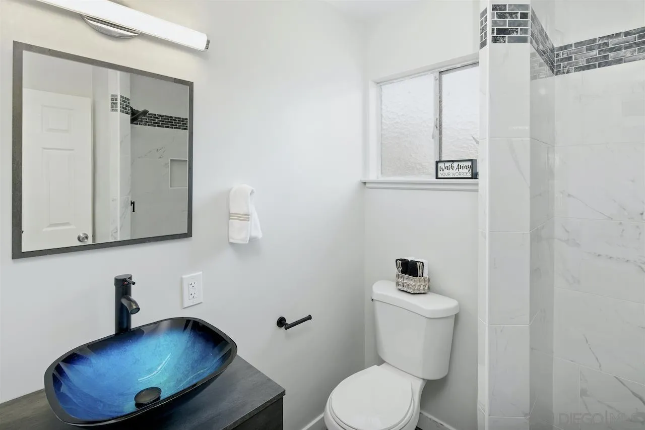 1050 Tiger Tail Road Vista, CA 92084 - Photo 15 of 28 a bathroom with a toilet sink and mirror
