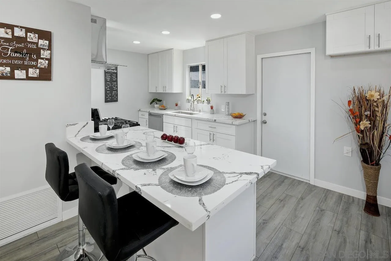 1050 Tiger Tail Road Vista, CA 92084 - Photo 5 of 28 a kitchen with kitchen island stainless steel appliances sink refrigerator dining table and chairs