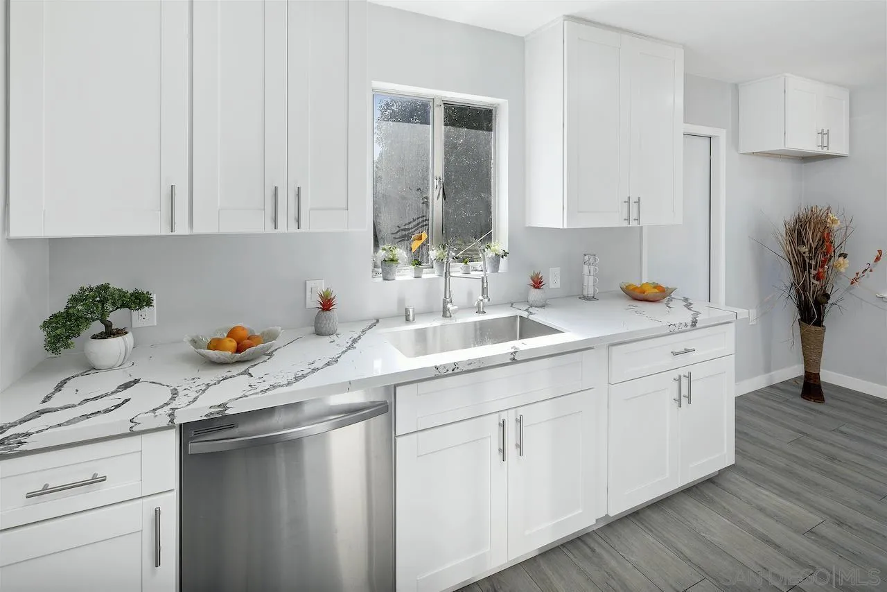 1050 Tiger Tail Road Vista, CA 92084 - Photo 8 of 28 a kitchen with white cabinets and a sink