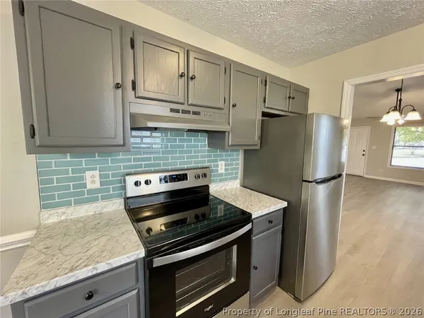 a kitchen with stainless steel appliances granite countertop a stove and a refrigerator