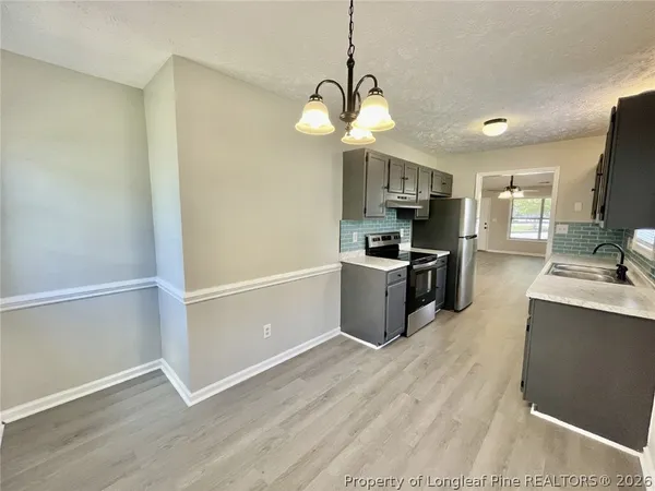 a kitchen with stainless steel appliances granite countertop a sink a stove top oven a refrigerator with island and chairs