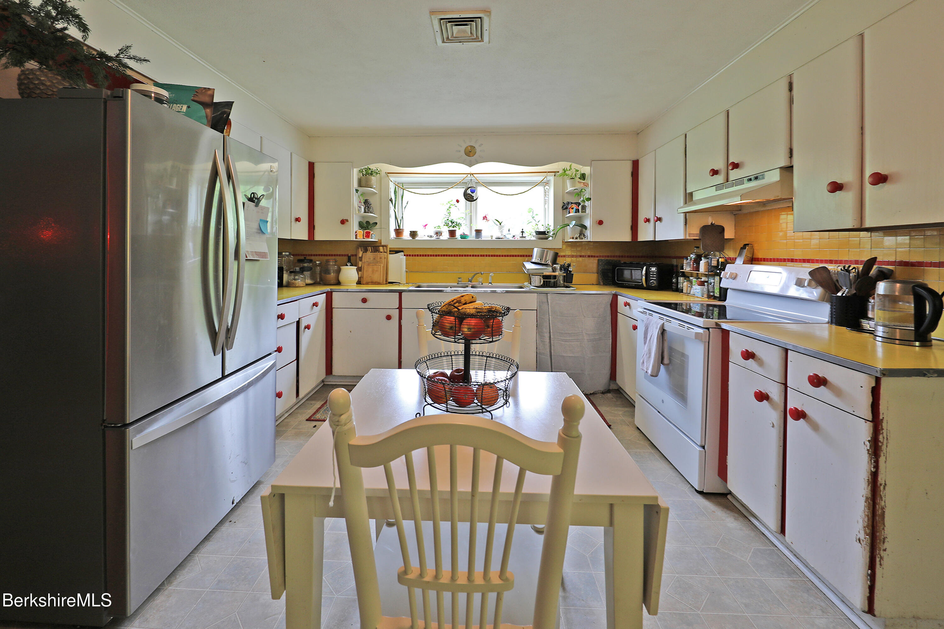 458 Monterey Road Great Barrington, MA 01230 - Photo 16 of 36 a kitchen with a refrigerator a stove a sink dishwasher and a dining table with wooden floor