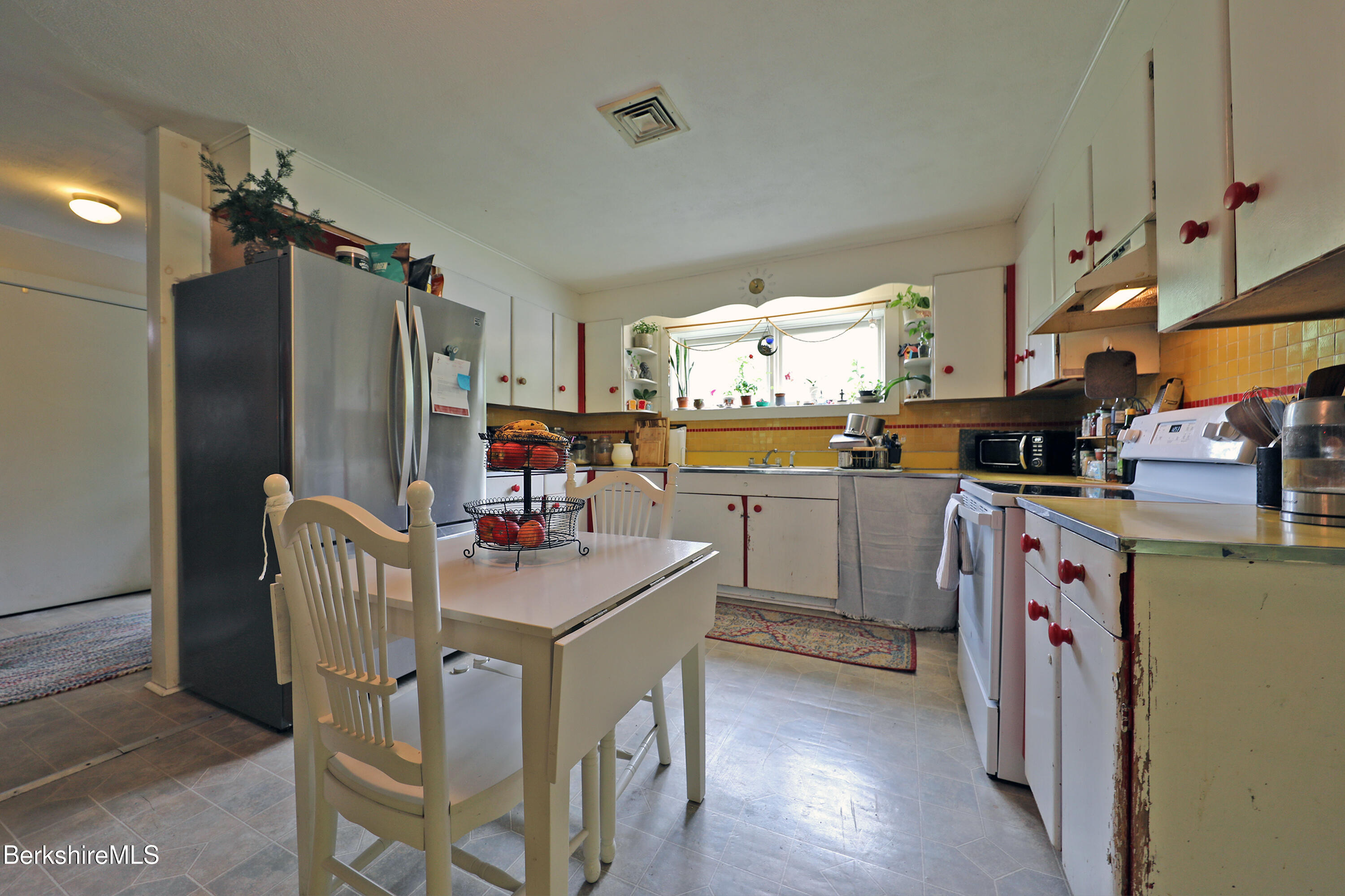 458 Monterey Road Great Barrington, MA 01230 - Photo 17 of 36 a kitchen with stainless steel appliances granite countertop a refrigerator a sink dishwasher a dining table and chairs with wooden floor