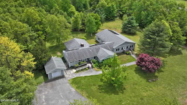 an aerial view of a house with garden space and street view