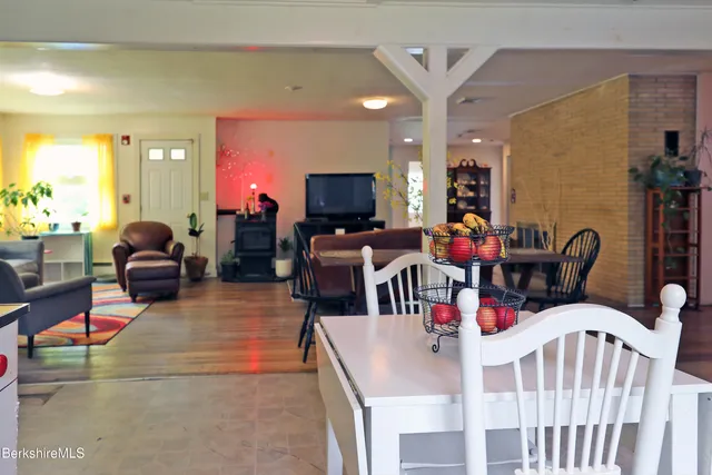 a living room with furniture kitchen view and a large window