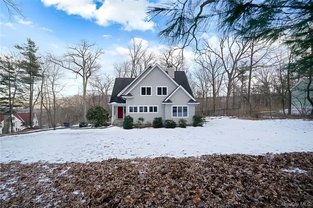 a front view of a house with a yard covered in snow